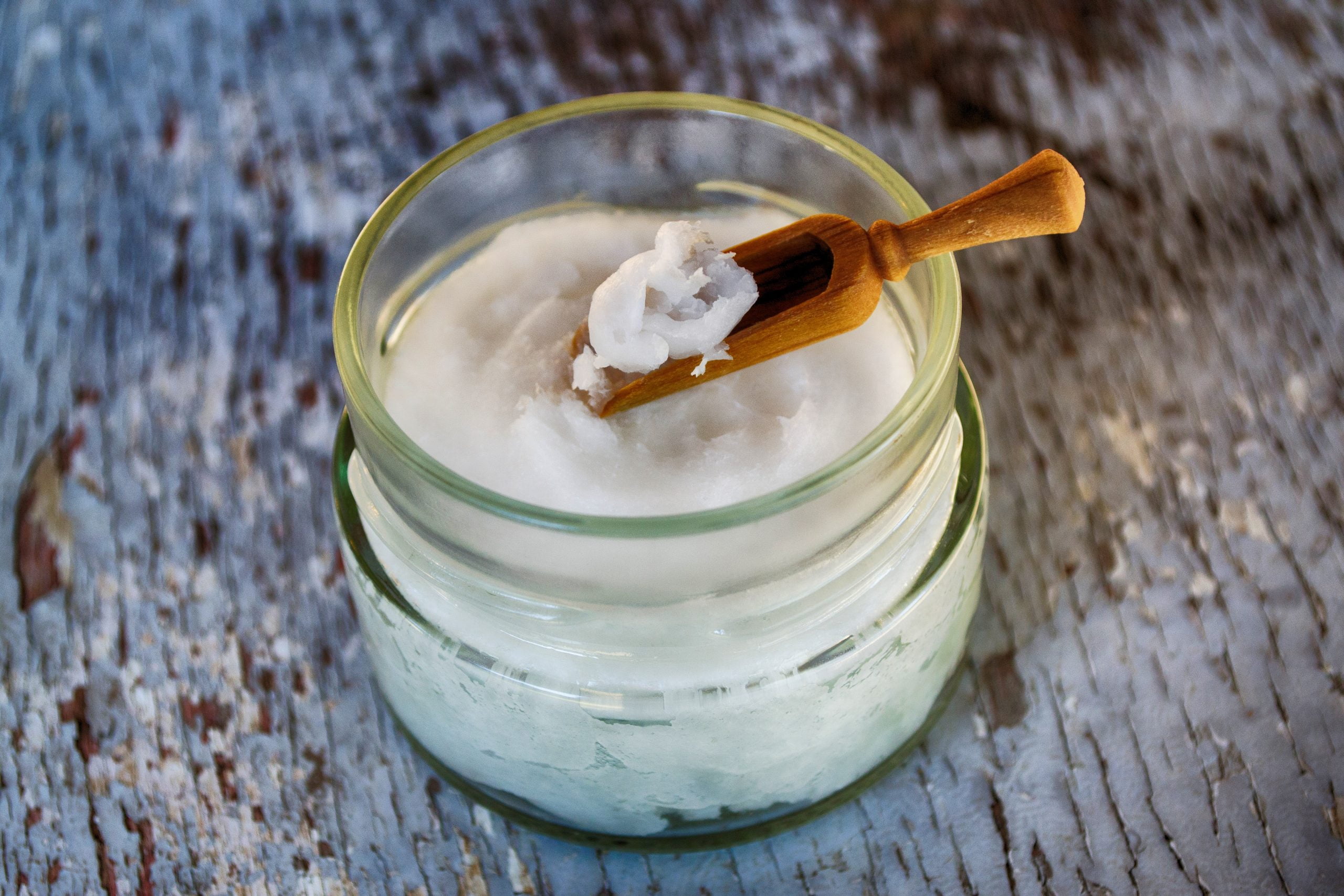Skin Care Skin Care Image. Glass jar of skin cream with small wooden spoon sitting on rustic wood surface.
